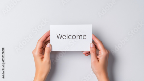 Pair of hands with different skin tones presenting a "Welcome" card, simple background, inclusivity, welcoming message, simplicity