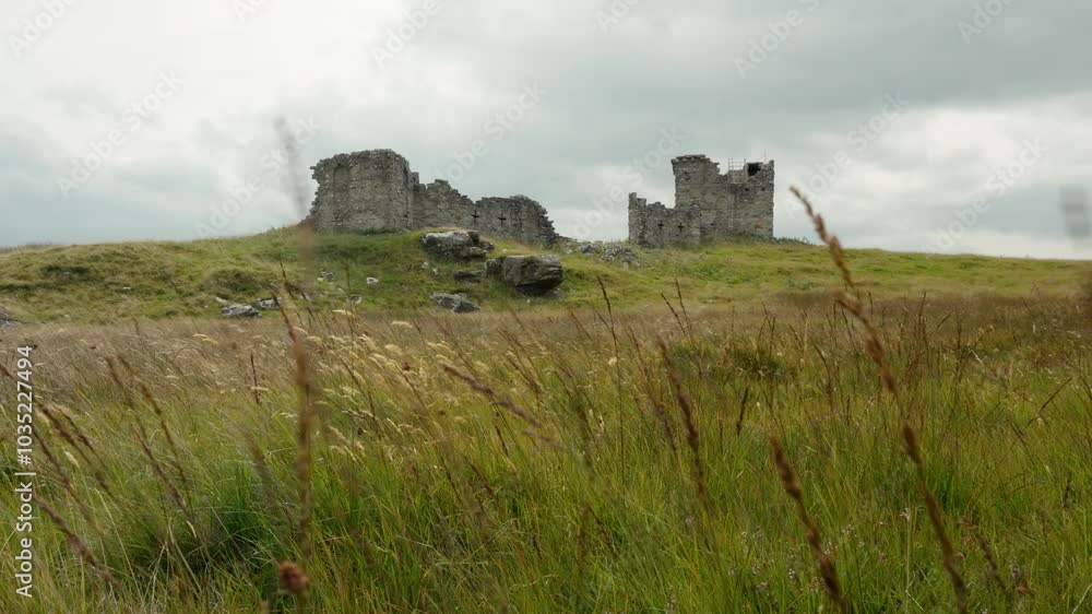 Ancient stone ruins on a grassy hill under a cloudy sky, captured in a wide shot Ancient stone ruins on a grassy hill under a cloudy sky, captured in a wide shot