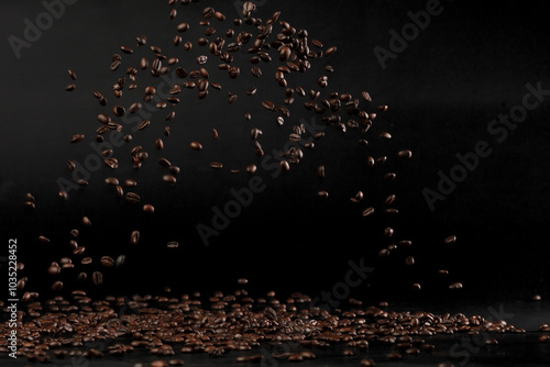 Coffee beans flying splashing in mid air. Black background isolated element. Many Coffee Beans flying explosion in air with aroma scent photo