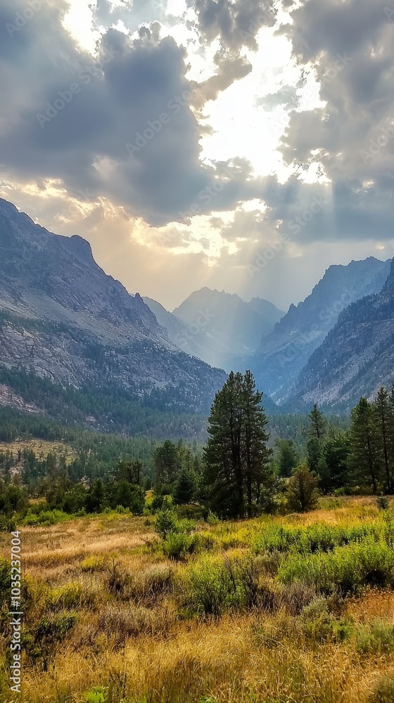 A breathtaking view of sun rays piercing through clouds over a serene mountain valley A breathtaking view of sun rays piercing through clouds over a serene mountain valley
