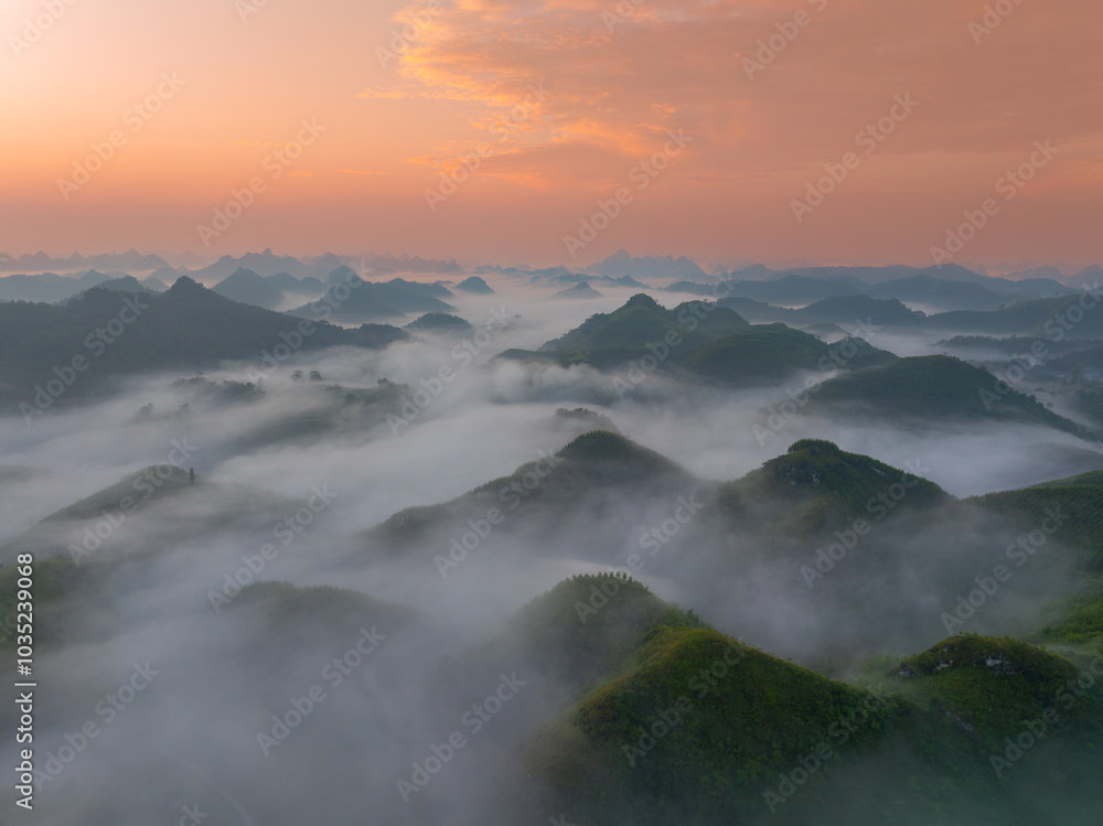 Orange sky and sea of clouds before sunrise. A peaceful, refreshing feeling. View of the hills surrounding Ba Quang, Ha Lang district, Cao Bang province, Vietnam Orange sky and sea of clouds before sunrise. A peaceful, refreshing feeling. View of the hills surrounding Ba Quang, Ha Lang district, Cao Bang province, Vietnam
