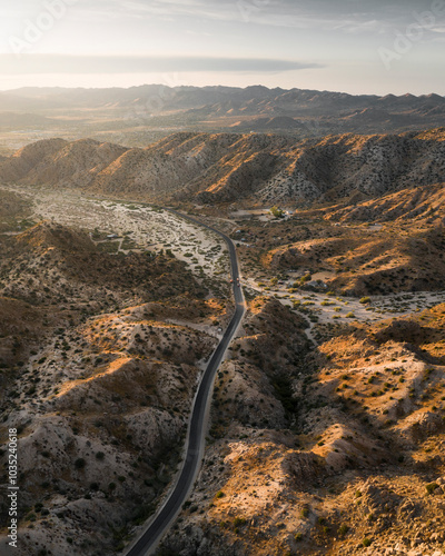 Aerial view of a beautiful desert landscape with a serpentine road and rugged mountains, Pioneertown, California, United States. photo