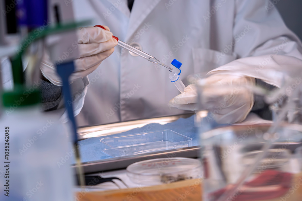 Police scientist analyzes bloody evidence in vial to discover the identity of suspect's DNA, concept image Police scientist analyzes bloody evidence in vial to discover the identity of suspect's DNA, concept image