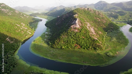 Aerial view of a picturesque river winding through lush mountains and a serene valley, Pavlova Strana Viewpoint, Old Royal Capital Cetinje, Montenegro. photo