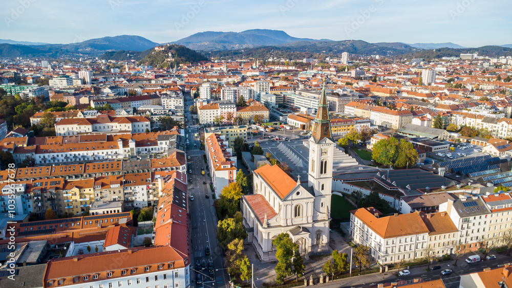 Aerial view of beautiful medieval church and vibrant city skyline with red rooftops, Graz, Austria. Aerial view of beautiful medieval church and vibrant city skyline with red rooftops, Graz, Austria.