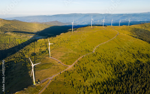 Aerial view of wind turbines on a sunny mountain ridge with lush pasture, Deutschlandsberg, Austria. photo