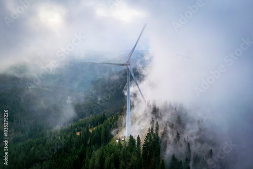 Aerial view of majestic mountains with wind turbines surrounded by clouds and forest, Voitsberg, Austria. photo