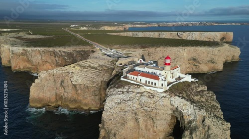 Aerial orbits lighthouse on Cape St Vincent, sea cliffs of Portugal