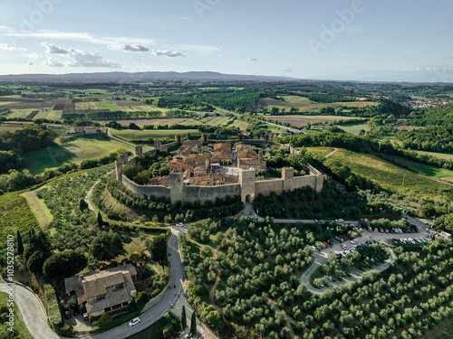 Aerial view of the medieval fortified town with stone walls and olive trees in a scenic landscape, Monteriggioni, Italy. photo