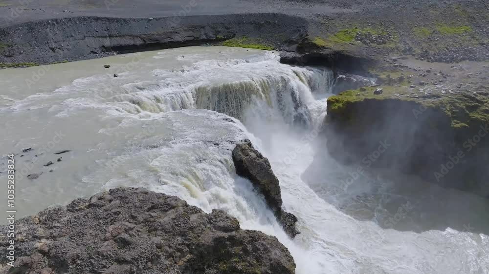 Aerial view of the majestic Sigoldufoss waterfall cascading over rugged rock formations, Sudruland, Iceland. Aerial view of the majestic Sigoldufoss waterfall cascading over rugged rock formations, Sudruland, Iceland.