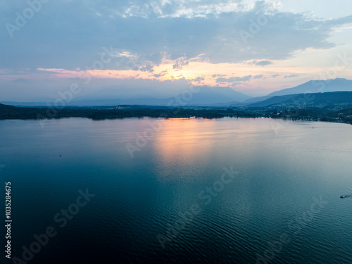 Wallpaper Mural Aerial view of tranquil Viverone Lake at sunset with majestic mountains and serene reflections, Viverone, Italy. Torontodigital.ca