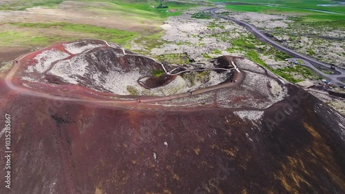 Aerial view of a majestic volcanic crater surrounded by rugged terrain and a vibrant pathway, Grabrok, Iceland. photo