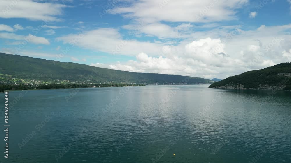Aerial view of serene Lake Annecy surrounded by majestic mountains under a clear sky, Duingt, France. Aerial view of serene Lake Annecy surrounded by majestic mountains under a clear sky, Duingt, France.