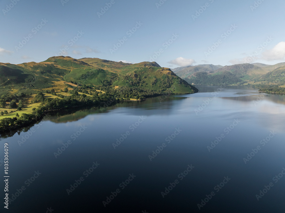 Aerial view of serene Ullswater lake surrounded by majestic mountains and lush greenery, Lake District, England. Aerial view of serene Ullswater lake surrounded by majestic mountains and lush greenery, Lake District, England.