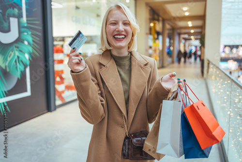 Happy Shopper Holding Bags and Credit Card in Mall photo