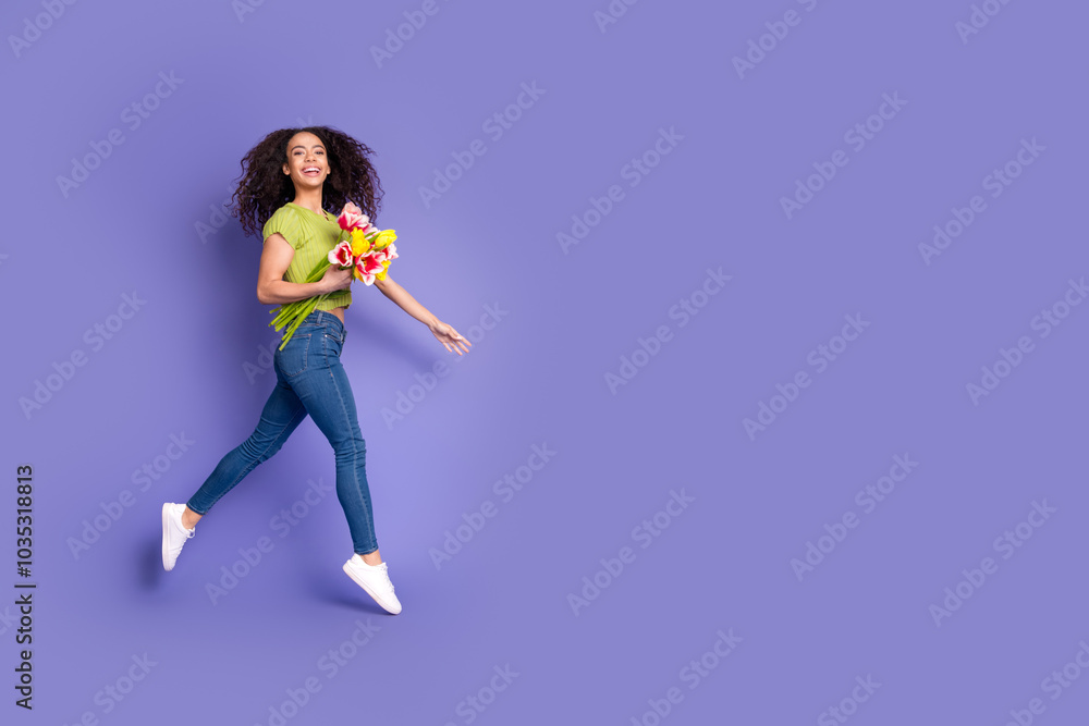 Full body photo of attractive teen woman hold tulips running dressed stylish green clothes isolated on purple color background Full body photo of attractive teen woman hold tulips running dressed stylish green clothes isolated on purple color background