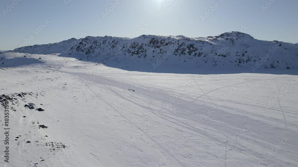 Sled Dogs Traversing Sunlit Snowfields Amidst Mountain Backdrop Sled Dogs Traversing Sunlit Snowfields Amidst Mountain Backdrop