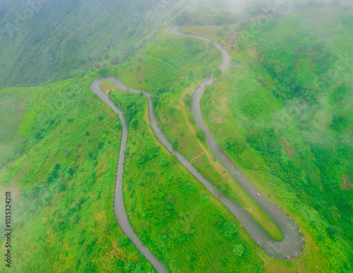 Aerial view of a beautiful winding mountain road through lush green landscape and valley, Obudu, Nigeria. photo