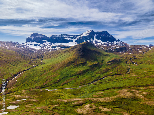 Aerial view of dyrfjallatindur mountain with a scenic valley and snowcapped peaks, Borgarfjordur, Iceland.