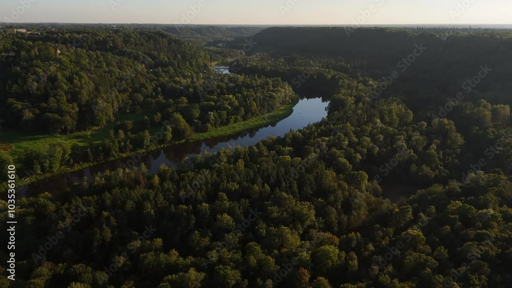 The Gauja River Snaking Through The Lush Green Verdant Forests Of Gauja National Park In Sigulda, Latvia. The Gauja River Snaking Through The Lush Green Verdant Forests Of Gauja National Park In Sigulda, Latvia.