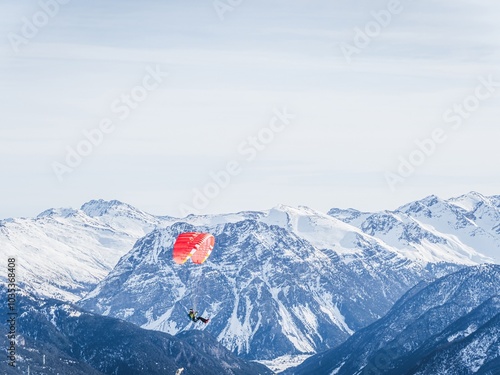 Paraglider over snowy mountains in Serre Chevalier, France