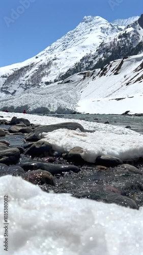 Melting snow in mountains feeding rivers that sustain ecosystems. It highlights impact of climate change on this delicate balance and calls for action to preserve these essential natural processes. photo