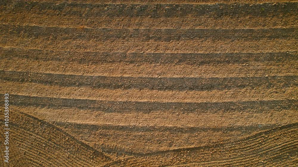 Patterns created on the soil of a freshly plowed field from an aerial perspective resembling waves. World Soil Day background with copy space. Patterns created on the soil of a freshly plowed field from an aerial perspective resembling waves. World Soil Day background with copy space.