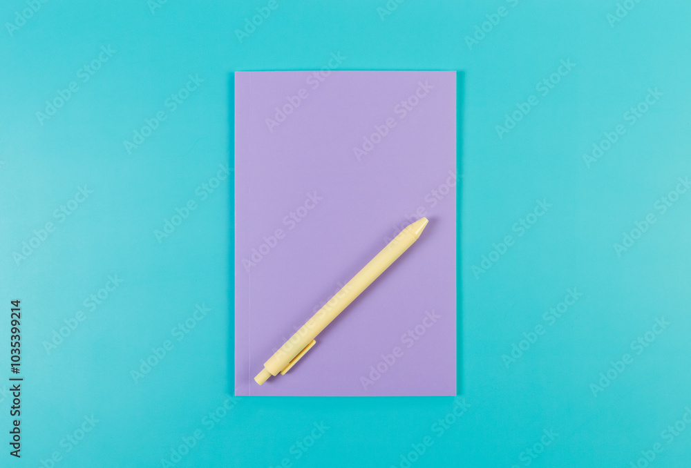 Top view of purple notebook, yellow pen on blue background. School, office wallpaper. Flat lay, copy space. Top view of purple notebook, yellow pen on blue background. School, office wallpaper. Flat lay, copy space.