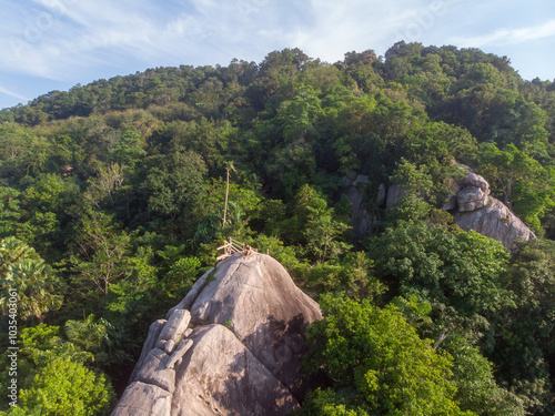 Canvas Print A serene view of a lush green forest surrounding a rocky hilltop.