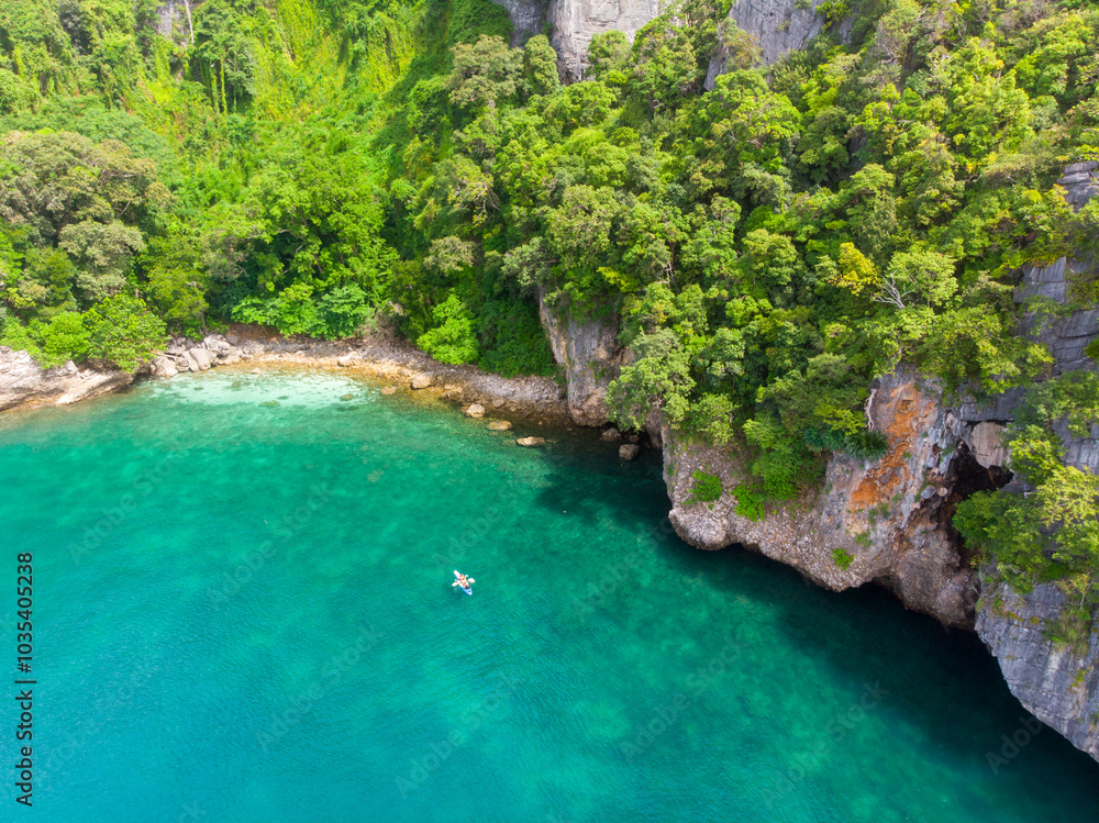 Aerial view of a secluded tropical cove with lush greenery and clear turquoise water. Aerial view of a secluded tropical cove with lush greenery and clear turquoise water.