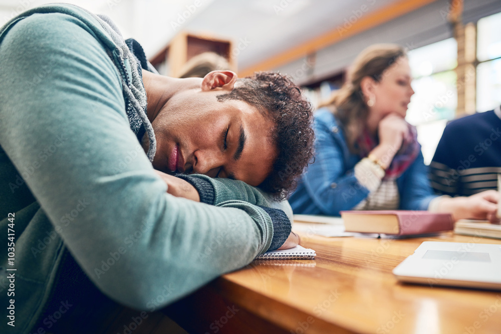 Man, student and sleep at college with group, burnout and tired with books, tech and education in library. Person, fatigue and exhausted with studying, learning and development in hall at university Man, student and sleep at college with group, burnout and tired with books, tech and education in library. Person, fatigue and exhausted with studying, learning and development in hall at university