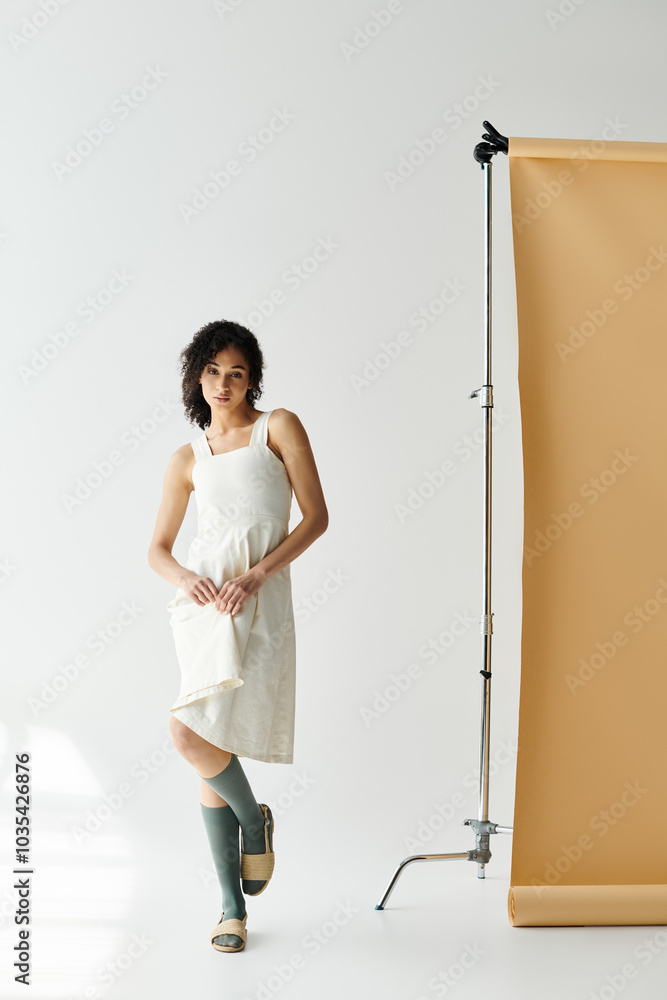 A fashionable woman stands gracefully, showcasing trendy attire in a bright, minimalist studio. A fashionable woman stands gracefully, showcasing trendy attire in a bright, minimalist studio.