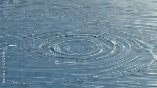 Rippling water with a single droplet creating a splash, capturing the essence of nature's beauty in shades of blue