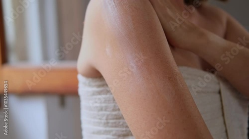 close up female hands and a smear of cream or lotion or serum on the skin, woman applies moisturizing cream or lotion after showering, daily body skin care routine