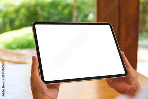 Mockup image of a woman holding digital tablet with blank desktop screen at home