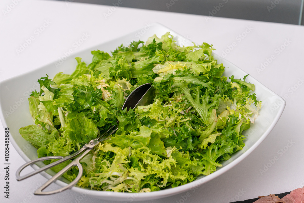 A fresh lettuce salad in a bowl, elegantly displayed on a hotel buffet. Perfect for showcasing healthy dining options and vibrant food presentation. A fresh lettuce salad in a bowl, elegantly displayed on a hotel buffet. Perfect for showcasing healthy dining options and vibrant food presentation.
