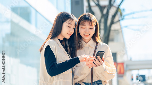 Tapety artystyczne 街中でスマホを見る友達同士の若い女性