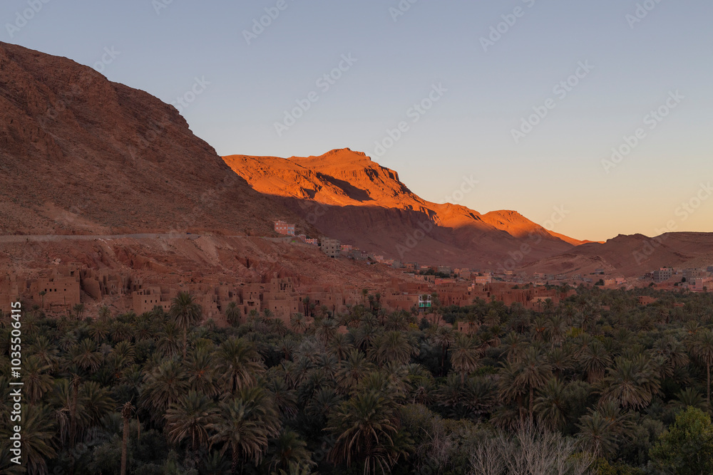 View of todra gorge with dramatic rock formations and palm trees at sunset, tinghir, morocco. View of todra gorge with dramatic rock formations and palm trees at sunset, tinghir, morocco.