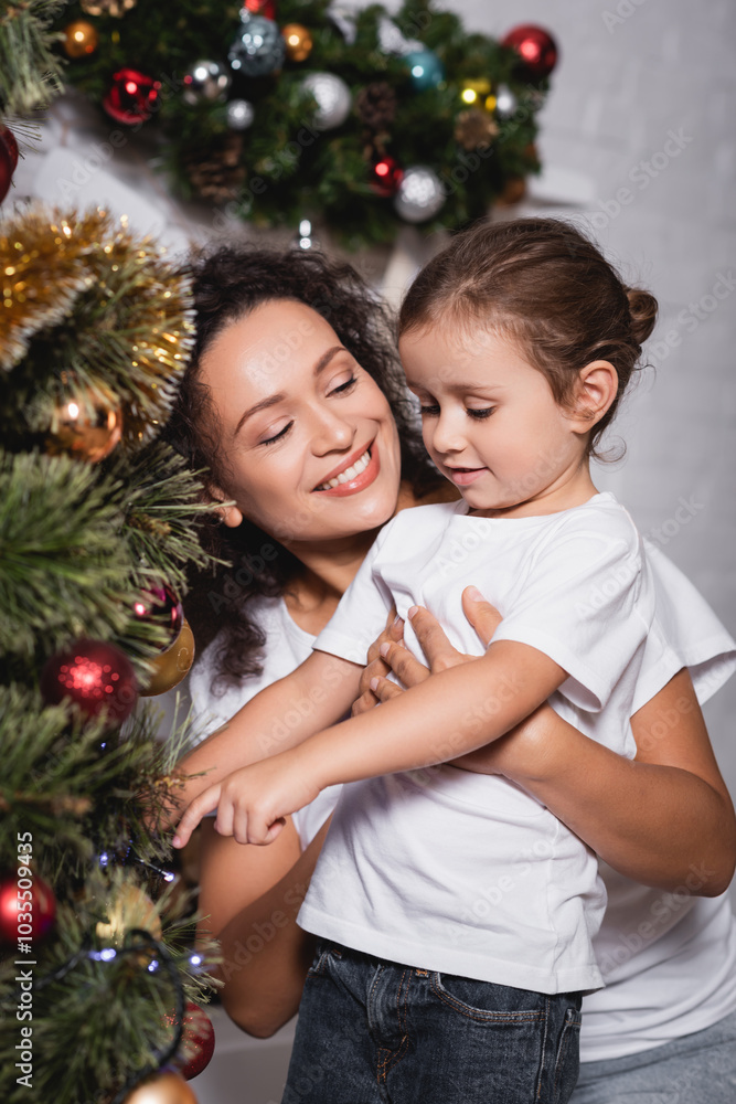 Mother hugging daughter near decorated Christmas tree at home Mother hugging daughter near decorated Christmas tree at home