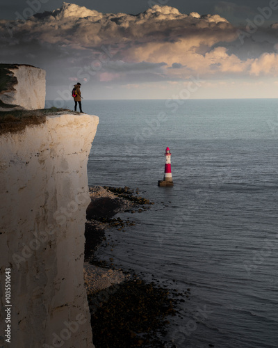 View of beachy head lighthouse on the rugged seven sisters cliffs overlooking the tranquil sea, eastbourne, united kingdom. photo