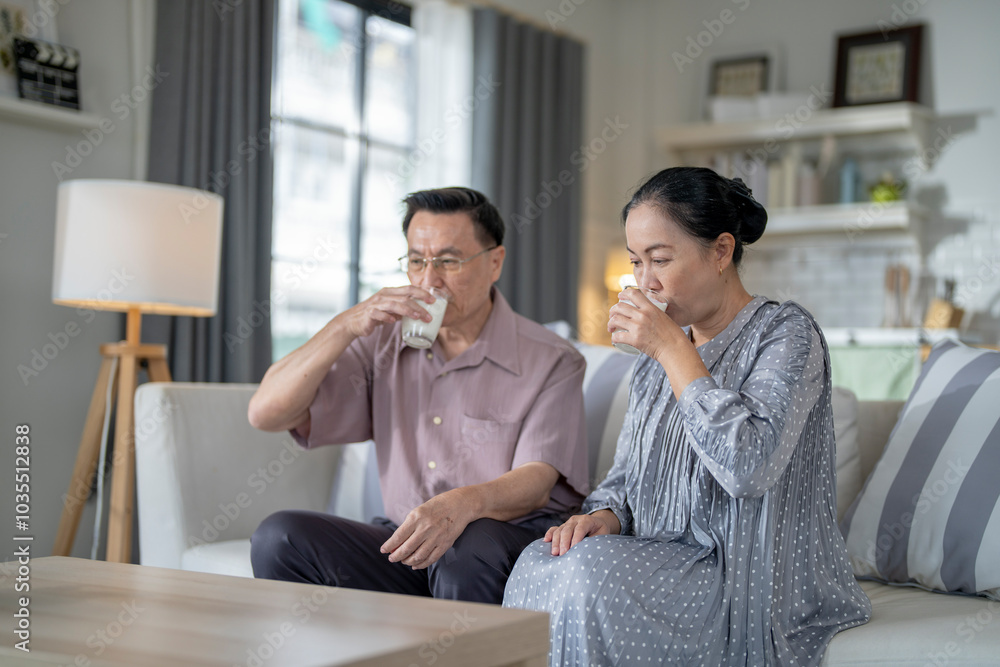 An elderly couple enjoys a peaceful moment at home, sharing smiles and drinks. The warm and cozy atmosphere emphasizes their deep connection, happiness, and the comfort of spending time together. An elderly couple enjoys a peaceful moment at home, sharing smiles and drinks. The warm and cozy atmosphere emphasizes their deep connection, happiness, and the comfort of spending time together.