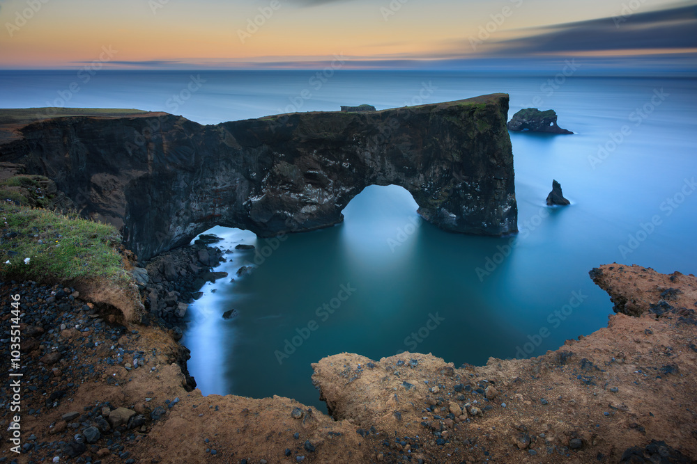 View of breathtaking Dyrholaey Promontory with rugged cliffs and serene ocean waves, Vik, Iceland. View of breathtaking Dyrholaey Promontory with rugged cliffs and serene ocean waves, Vik, Iceland.