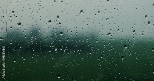 window with rain. rain falling on a window. background of rain on a window cinematic look. raindrops falling on a window