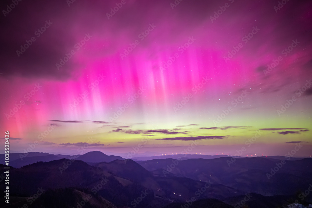 View of northern lights over tranquil mountains in a colorful sky, Almenland, Austria. View of northern lights over tranquil mountains in a colorful sky, Almenland, Austria.