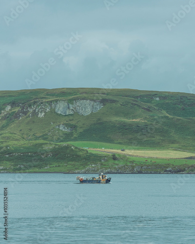 View of tranquil boat on serene water surrounded by lush hills, Lochgilphead, United Kingdom. photo