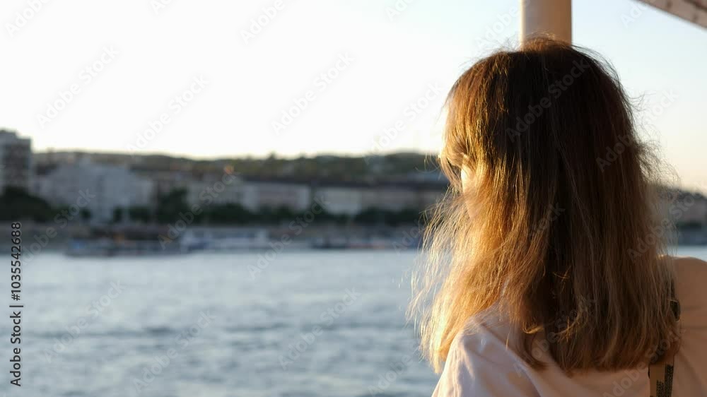 Female enjoying serene boat ride along Danube in Budapest city back view riverbanks. Young woman leisurely cruising on Danube River with Budapest impressive architecture stunning backdrop. Female enjoying serene boat ride along Danube in Budapest city back view riverbanks. Young woman leisurely cruising on Danube River with Budapest impressive architecture stunning backdrop.