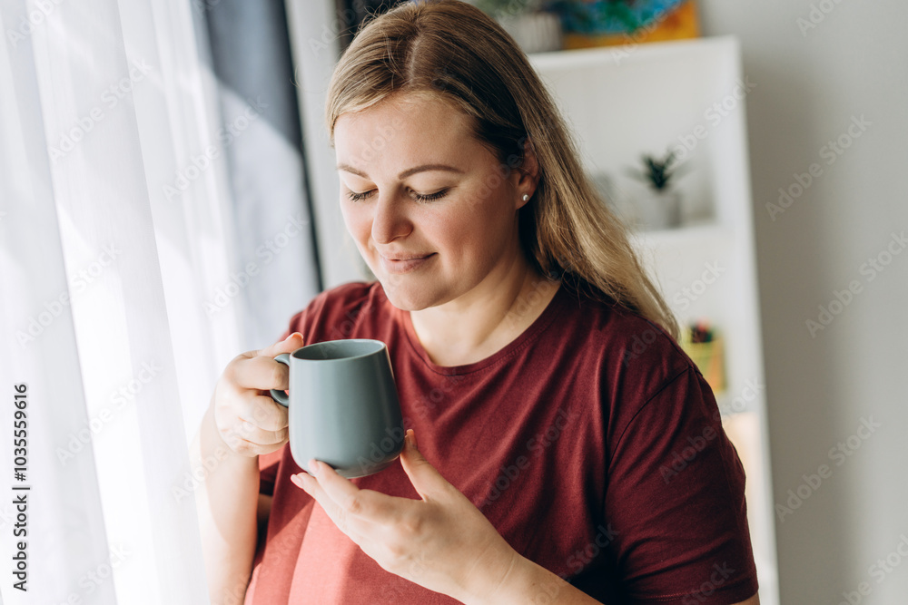 Caucasian pretty woman looking at cup of coffee posing at home at home Caucasian pretty woman looking at cup of coffee posing at home at home