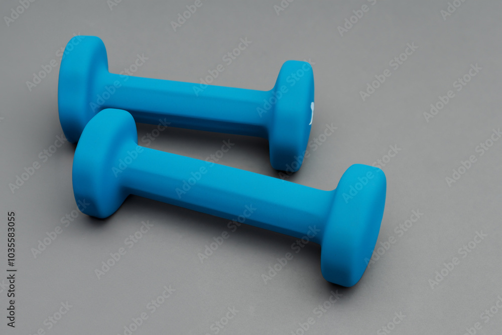 Gray with weighted swatch of blue. weight fitness health concept. man sports small weights on a gray . a man sports a small tan weights lifestyle on a gray. Gray with weighted swatch of blue. weight fitness health concept. man sports small weights on a gray . a man sports a small tan weights lifestyle on a gray.