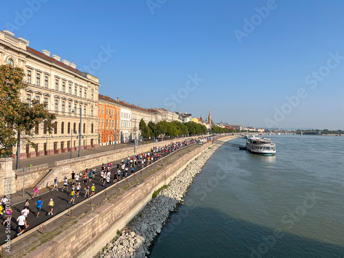 crowd people running marathon race along embankment in Budapest