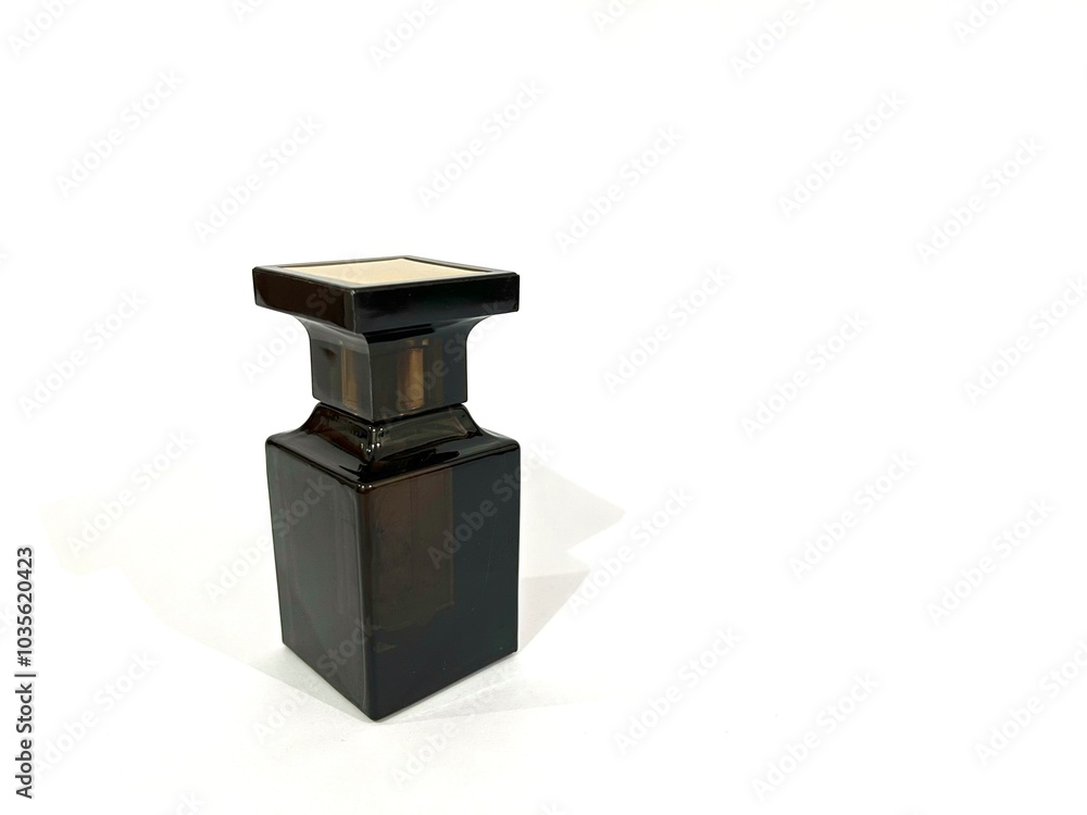 Luxury and elegant perfume bottle with unique shape made from dark brown color glass isolated on white background Luxury and elegant perfume bottle with unique shape made from dark brown color glass isolated on white background